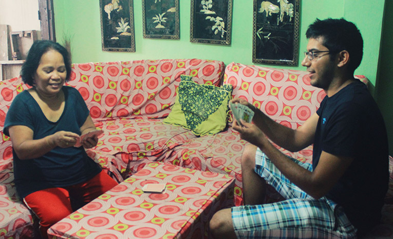 A volunteer playing cards with his host family
